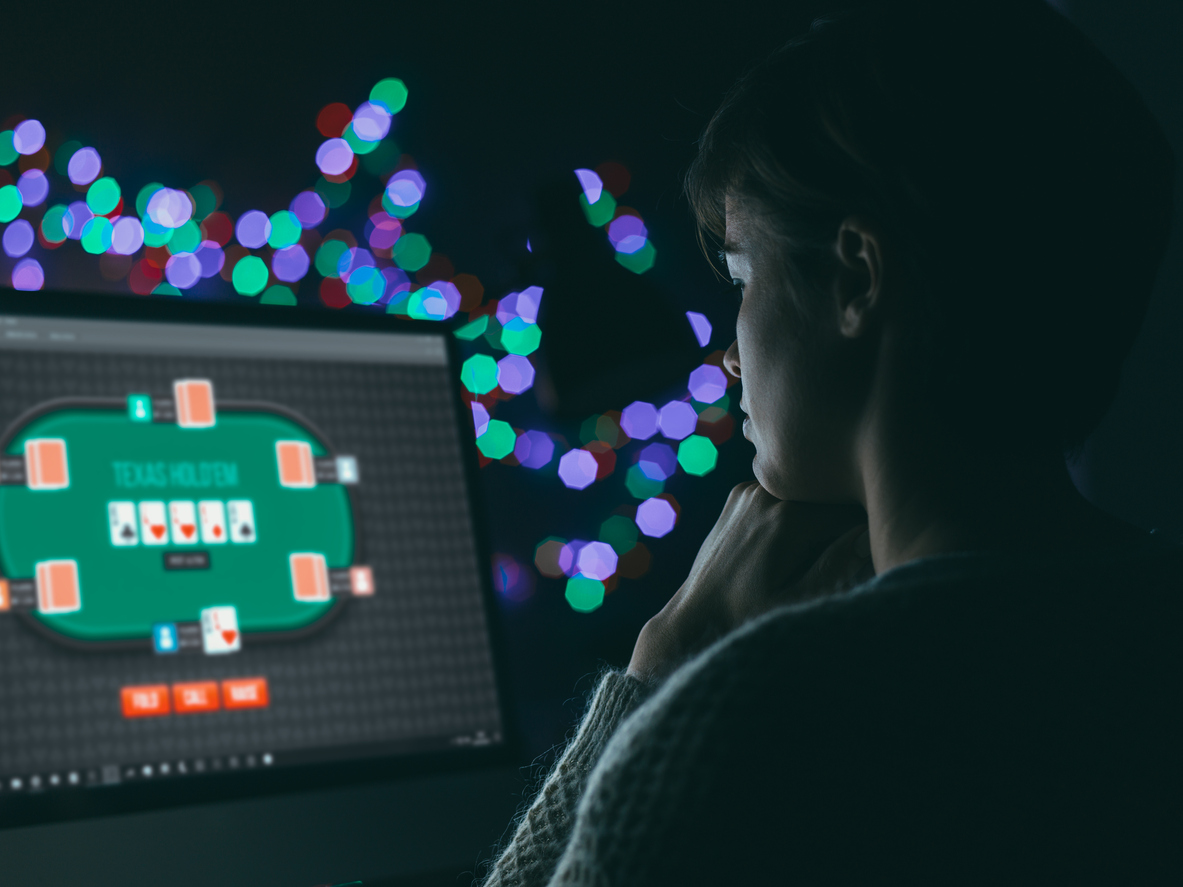 Woman playing online poker late at night. Top 3 Reasons to Play Online Poker Only on Regulated Sites