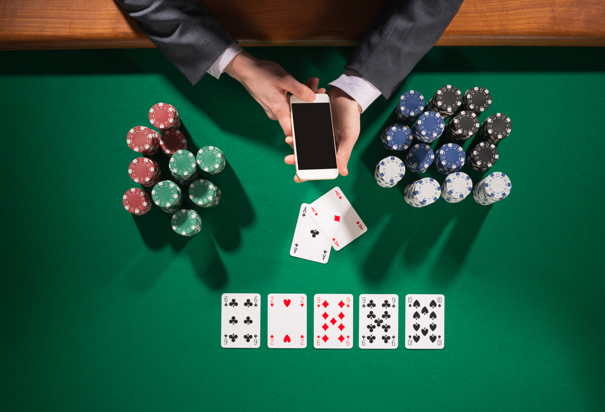 male poker player using a smartphone, cards and chips stacks all around, green table top view -- WSOP Issues Reminder: No Solvers Allowed During Hands